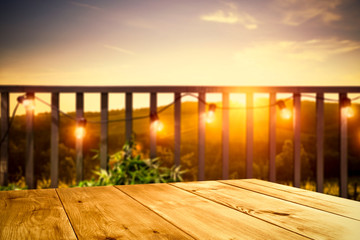 Canvas Print - Wooden board of free space for your decoration. Blurred background of balcony and ladnscape of Tuscany.Small lights and orange color of sunset time. 