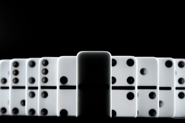 Domino pieces put in a row on black background