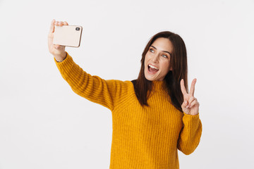 Wall Mural - Image of brunette adult woman smiling and taking selfie on cellphone