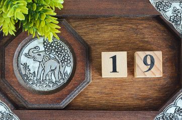 Number 19, Numbercube design with wooden board for background.