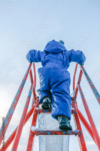 Fotografía Rear View Of Boy On Slide Against Sky During Winter