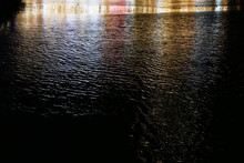 街の照明が反射する夜の川の水面