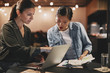 © Flamingo Images - Diverse businesswomen sitting at a table working on a laptop