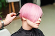 © okskukuruza - Hairdresser combing short pink hairstyle of young woman, close up.