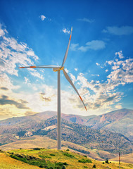 Wall Mural - wind turbine on a hill against the sunset sky