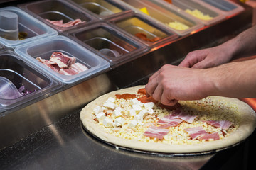 Closeup hand of chef baker making pizza at kitchen of pizzeria