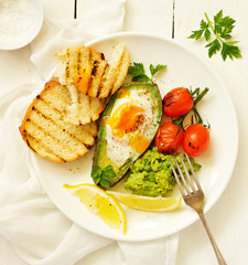 Sticker - Fried eggs in avocado with guacamole sauce. Breakfast. Selective focus