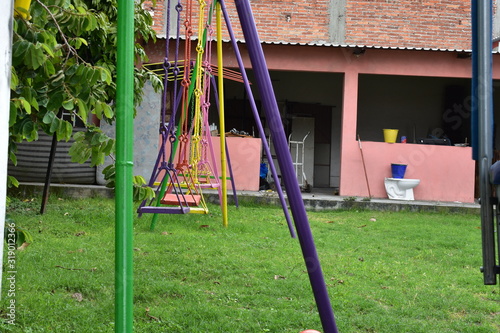 columpios de fierro multicolores en patio de juego con fondo de pared rosa - Buy this stock photo and explore similar images at Adobe Stock | Adobe Stock