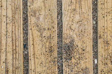 Closeup top view of wooden walk way at sandy beach. Horizontal color flatlay photography.