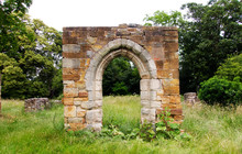 Ruined Stone Archway In Grassy Field