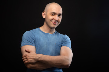 Wall Mural - Photo of smiling bald man in blue tee shirt with arms crossed