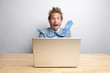 © PeskyMonkey - Surprised businessman freaking out in front of his computer while sitting at his desk