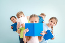 Cute Little Children With Books On Color Background