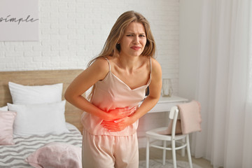 Canvas Print - Young woman suffering from menstrual cramps at home