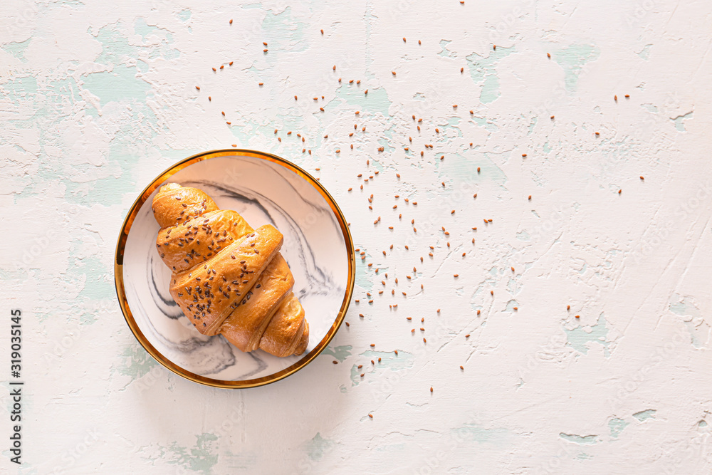 Plate with tasty croissant on white background