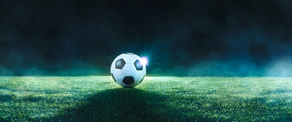 Poster - Football on an illuminated empty sports field at night