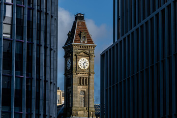 Wall Mural - Old clock tower between new glass buildings