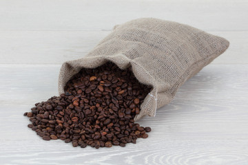 Coffee beans and hessian bag on wood