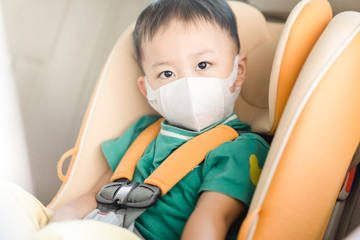 Wall Mural - Coronavirus and Air pollution pm2.5 concept.Little chinese boy wearing mask for protect pm2.5.in car seat in the car.Corona virus outbreak.Wuhan coronavirus, epidemic virus symptoms and travel.