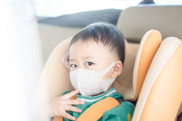 Wall Mural - Coronavirus and Air pollution pm2.5 concept.Little chinese boy wearing mask for protect pm2.5.in car seat in the car.Corona virus outbreak.Wuhan coronavirus, epidemic virus symptoms and travel.