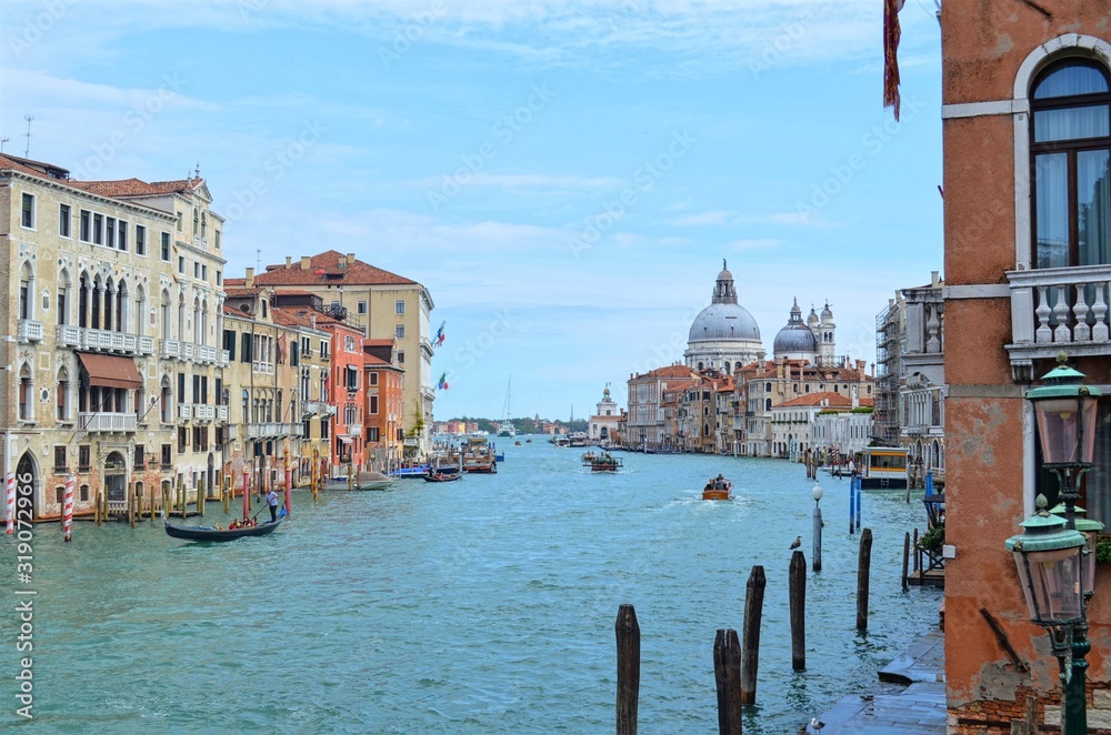 panoramic view of the wide Venetian canal, with the domes of the Basilica Della Salute in the background - obrazy, fototapety, plakaty 