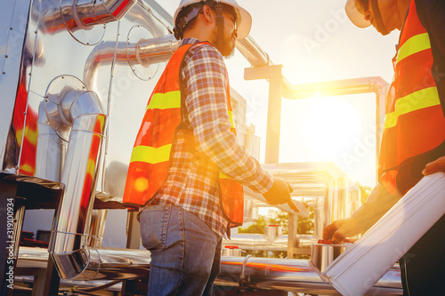 Fotomural Architect and engineer construction workers consulting and discuss while working at cooling machine factory