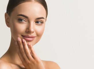 beautiful woman face close up natural make up hand touching face beauty smile