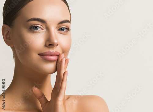 Fotografía Beautiful woman face close up natural make up hand touching face beauty smile
