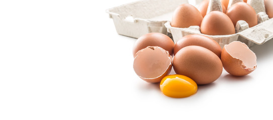 Chicken eggs and broken egg with yolk isolated on white background