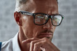 © Svitlana - You choose what to do. Close up of middle-aged caucasian trader in glasses looking focused while working in the office.