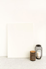 Wall Mural - Blank canvas with empty mockup copy space and candle lantern. Minimal artist studio interior concept.