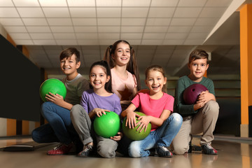 Wall Mural - Happy children with balls in bowling club