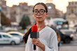 © Svitlana - TV reporter presenting the news outdoors. Journalism industry, live streaming concept.