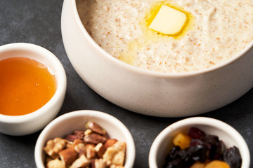 Wall Mural - Oatmeal porridge with raisins, honey and nuts in a bowl