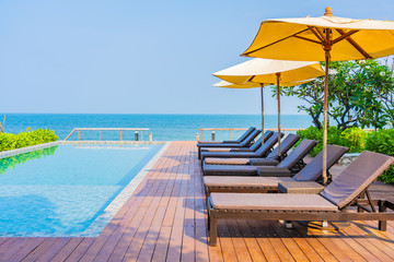 Beautiful empty chair umbrella around outdoor swimming pool in hotel resort for travel