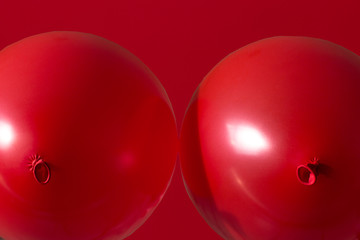 Wall Mural - two red helium balloons on red background