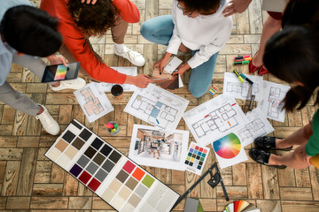 Wall Mural - discussing sketches. group of young interior designers in casual clothes working on a new project, c