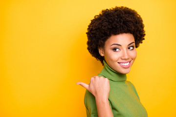 Canvas Print - Close up turned photo of cheerful positive nice trendy woman pointing into empty space with her thumb smiling toothily isolated vibrant color background