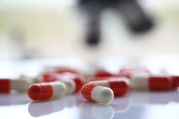 Red tablets scattered on the table of the pharmaceutical laboratory pill for the prescription and treatment of various diseases chemistry