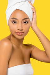 Wall Mural - portrait of african american young woman with towel on head, isolated on yellow