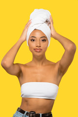 Wall Mural - portrait of beautiful african american girl with towel on head, isolated on yellow