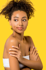 Wall Mural - portrait of african american girl with clean face, isolated on yellow