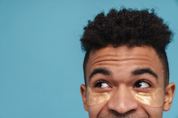 Wall Mural - Photo of african american man with under eye patches looking upward