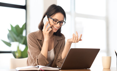 Happy girl talking on the phone at office