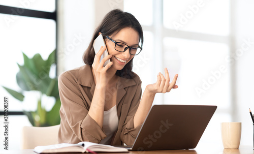 Cuadros en Lienzo Happy girl talking on the phone at office