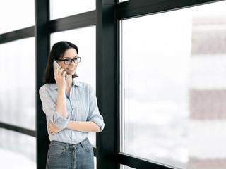 Wall Mural - European girl talking on cell phone at office