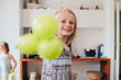 © Eugenio Marongiu - Young beautiful female child indoor at home playing with balloon looking camera smiling