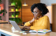 © Prostock-studio - Black girl working in cafe, browsing on laptop