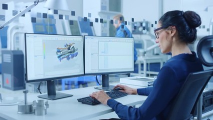 Poster - Industrial female Engineer Working on a Personal Computer, Two Monitor Screens Show CAD Software with 3D Prototype of Engine and Charts. Modern Factory with High-Tech Machinery