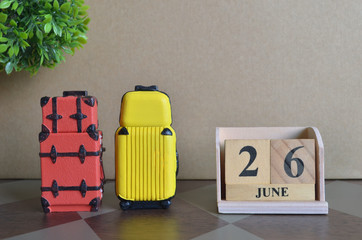 Appointment Date, June 26, Holiday, Travel cover with number cube and luggage.